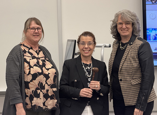 Passing of the presidential gavel from Gabriela Olivares to Lia Plakans and Pam Wesely.